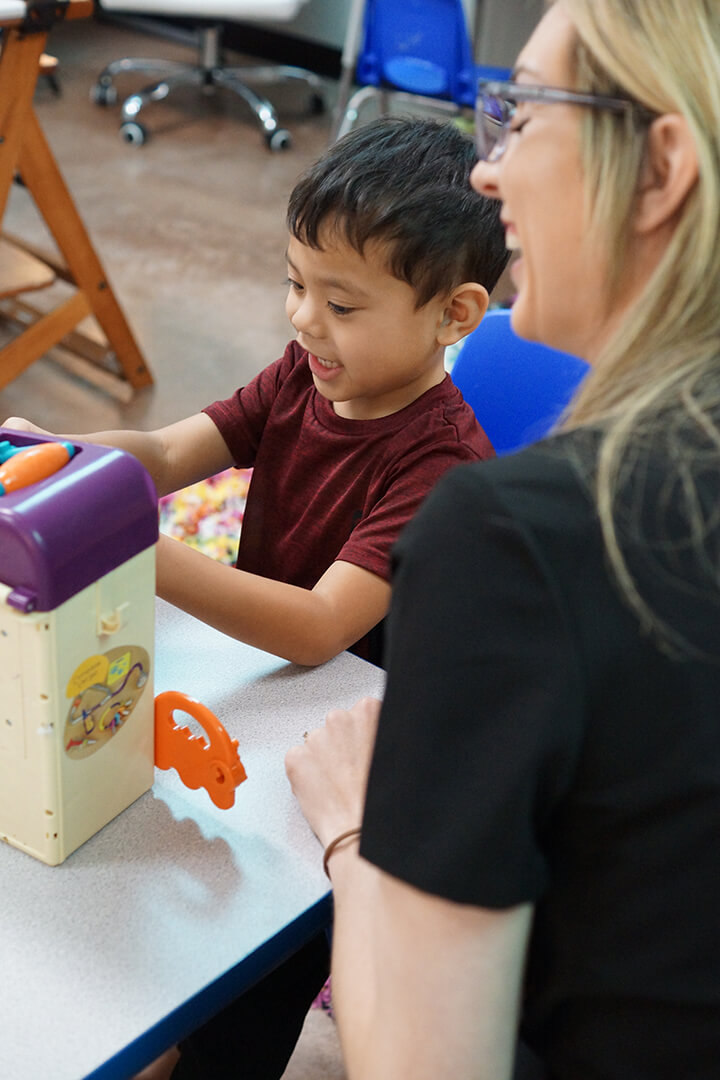 Child playing with toys laughing teacher